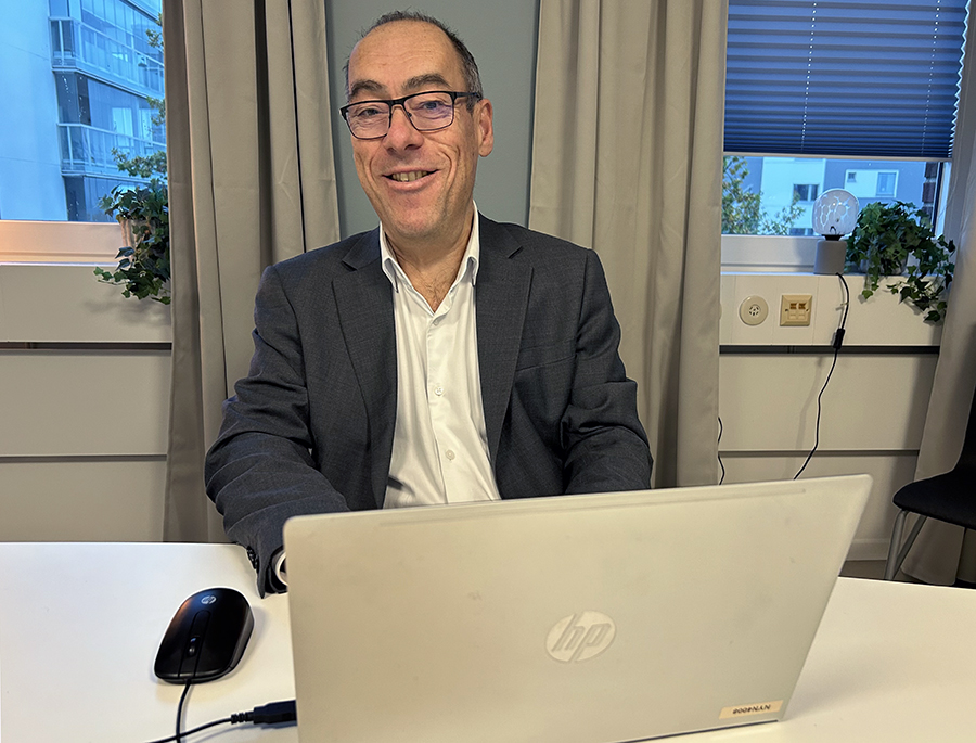 Man med dator i inomhusmiljö