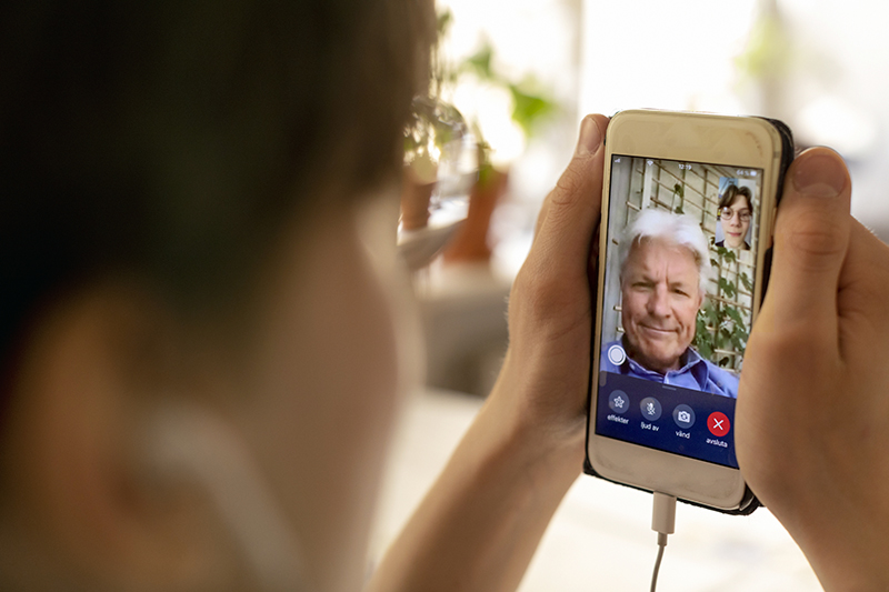En mans ansikte syns på ett videosamtal i en smarttelefon
