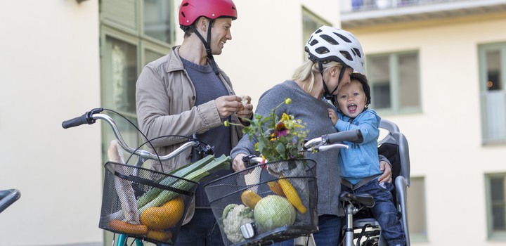 Man och kvinna med son på cykel i barnsits