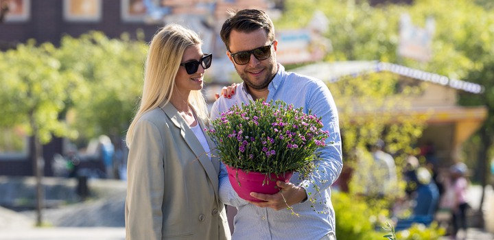 Kvinna och man tittar på blommor vid torghandel